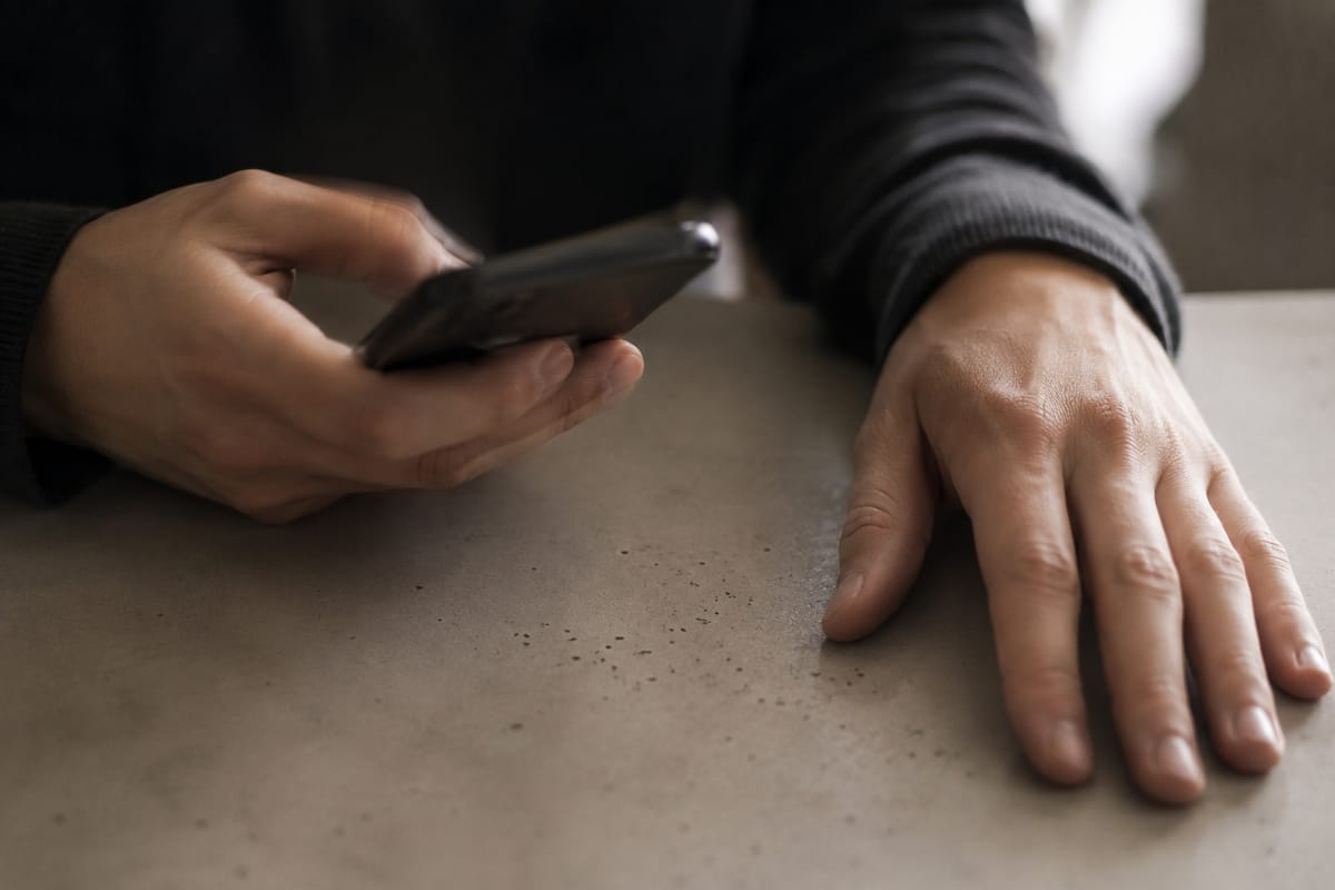 Gros plan sur une main tenant un téléphone affichant un billet instantané